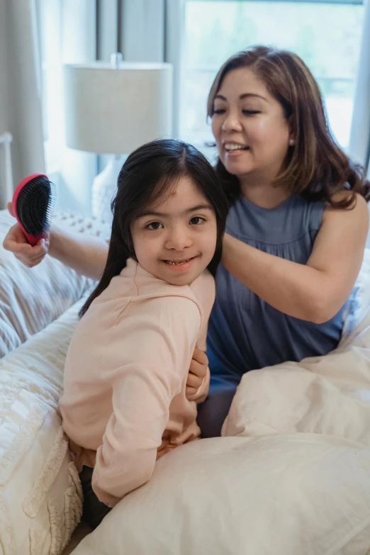 a woman combing a little girl's hair on a bed, pexels contest winner, looking confident, manila, soft and fluffy, gif