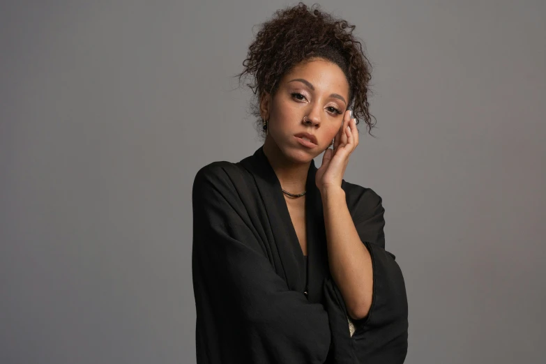 a woman holding a cell phone to her ear, an album cover, inspired by Afewerk Tekle, pexels contest winner, renaissance, oona chaplin, studio portrait photo, looking serious, wearing a black robe