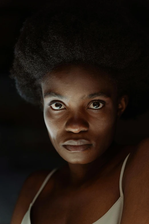a close up of a person with an afro, by Chinwe Chukwuogo-Roy, pexels contest winner, hyperrealism, police lights shine on her face, girl under lantern, unreal engine. film still, bedroom eyes