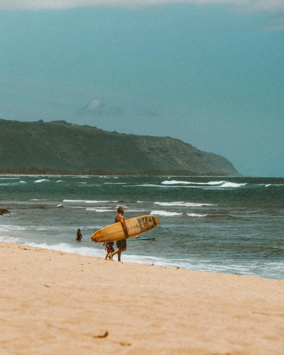 a person walking on a beach with a surfboard, on the ocean