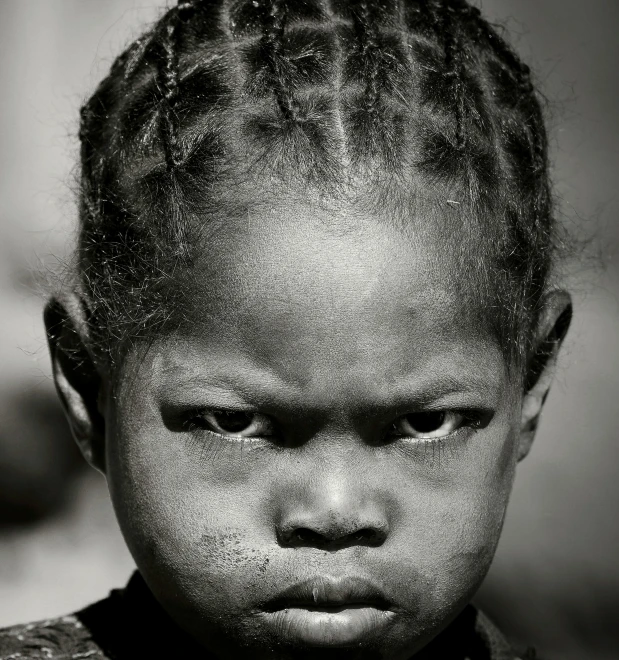 a black and white photo of a young girl, by Joze Ciuha, hurufiyya, angry look, african, pupil, intricate ”