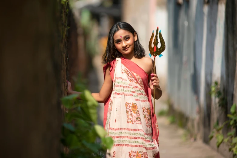 a woman in a sari holding a stick, pexels contest winner, bengal school of art, holding a trident, avatar image, teenage girl, wearing festive clothing