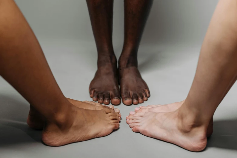 a couple of feet standing next to each other, trending on pexels, hyperrealism, varying ethnicities, with grey skin, three colors, wearing nothing