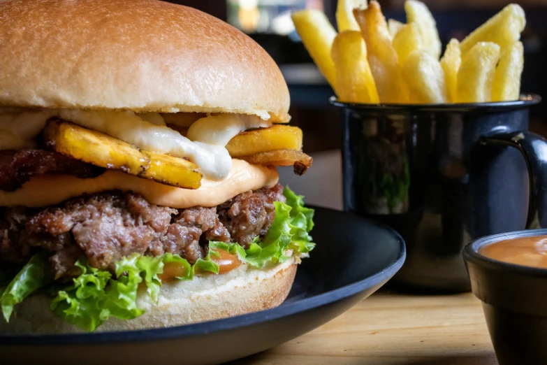 a hamburger sitting on top of a black plate next to fries, unsplash, bao phan, 🦩🪐🐞👩🏻🦳, local close up, avatar image