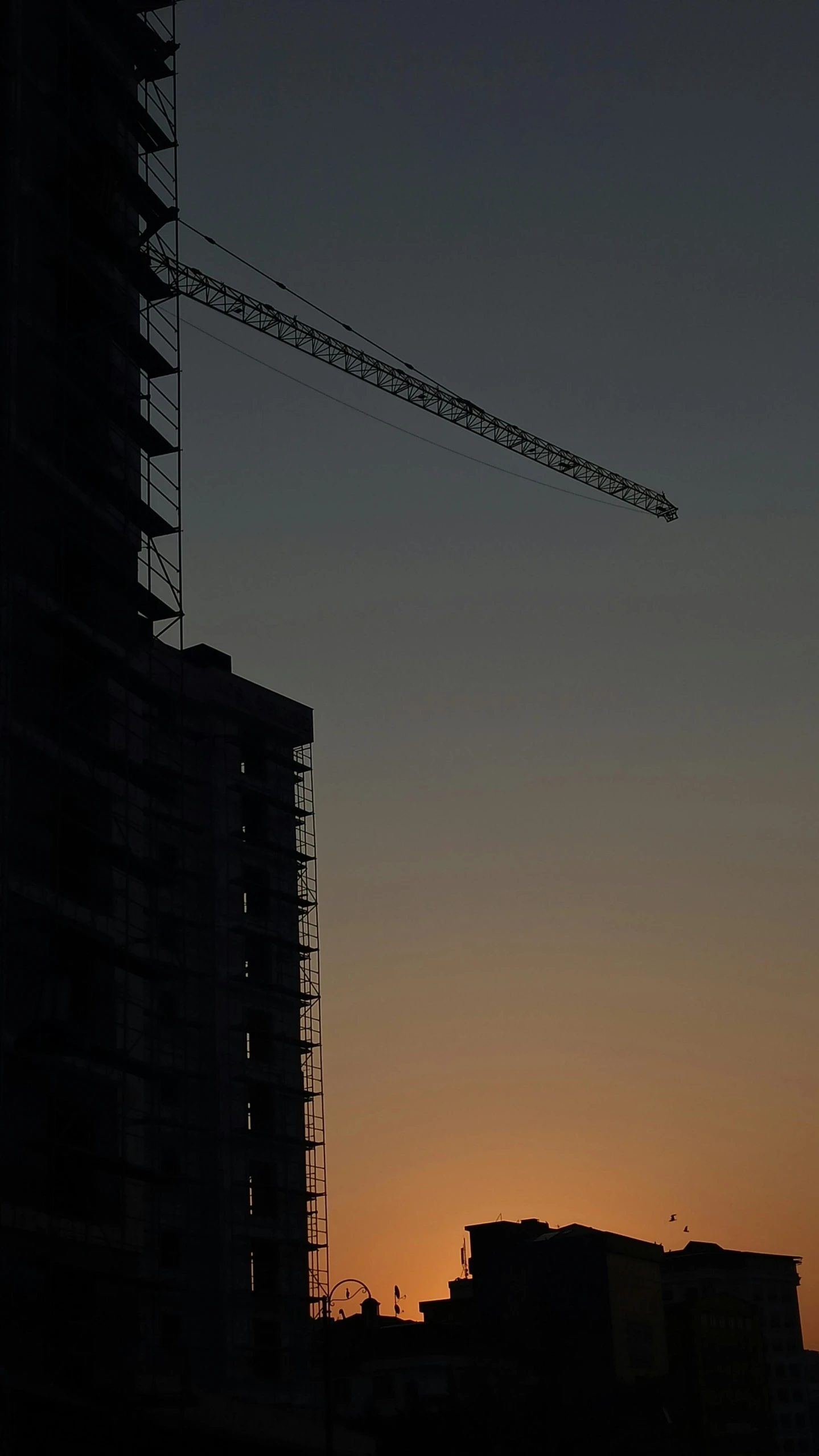 a construction crane is silhouetted against the setting sun, by Attila Meszlenyi, brutalism, grey, high quality photo, 8k 50mm iso 10, (night)