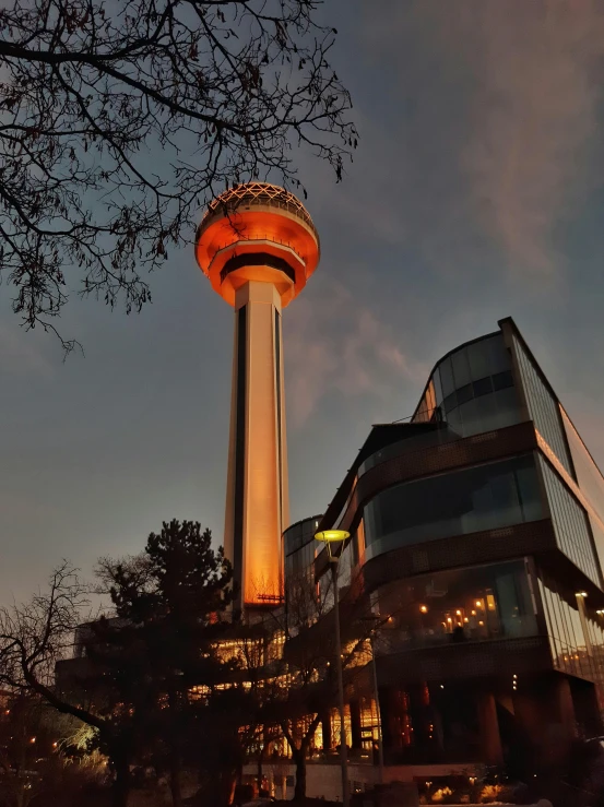 a tall tower sitting in the middle of a city, by Alejandro Obregón, unsplash contest winner, brutalism, futuristic pizza hut at night, istanbul, 1980 photo, golden hour 4k