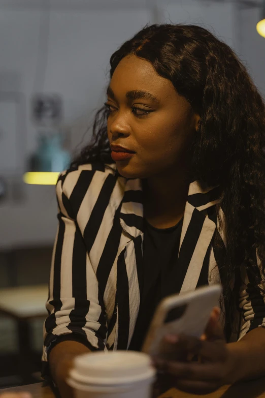 a woman sitting at a table using a cell phone, mkbhd, pictured from the shoulders up, still cinematic, low quality photo