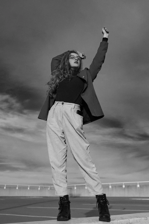 a woman standing on top of a tennis court holding a racquet, a black and white photo, trending on pexels, renaissance, long ginger hair windy, wearing a turtleneck and jacket, hands up, imaan hammam