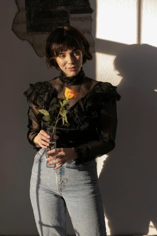 a woman standing in front of a wall holding a rose, an album cover, by Winona Nelson, renaissance, see - through, mary elizabeth winstead, ivy vine leaf and flower top, wearing victorian rags