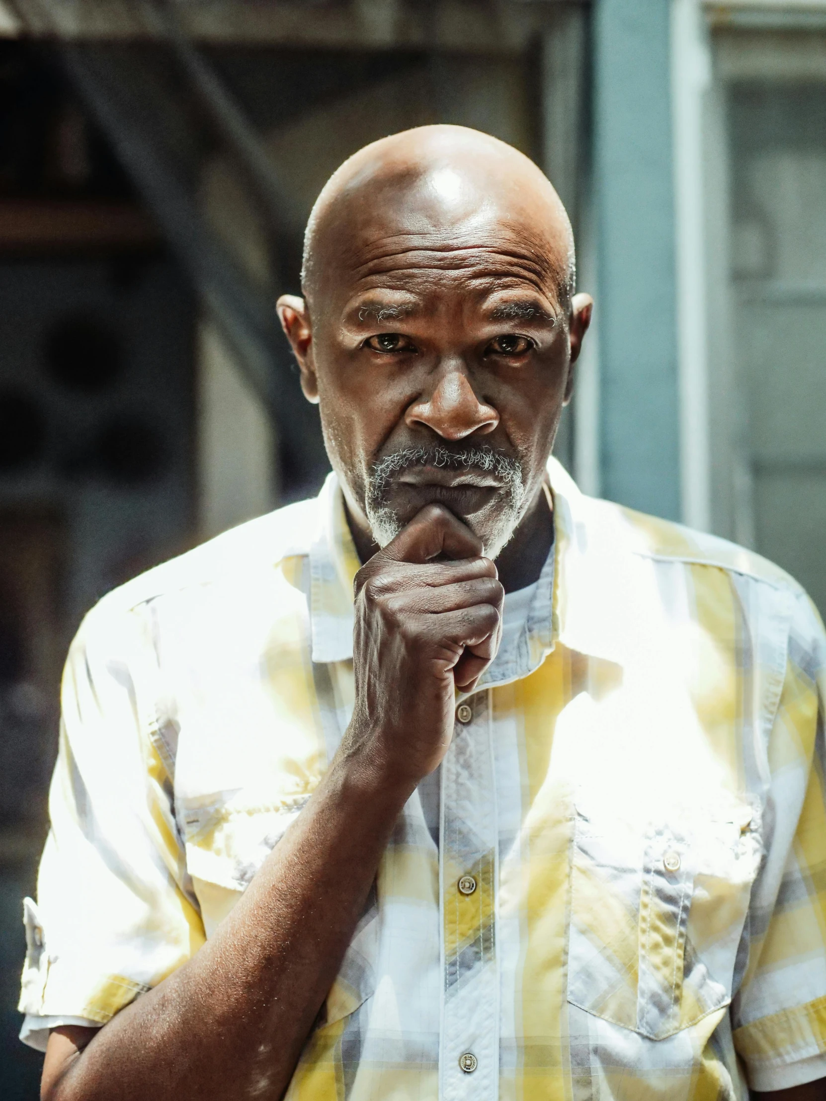 a man standing in front of a building with his hand on his chin, a portrait, by Everett Warner, trending on unsplash, augusta savage, steve harvey as the flash, 2 5 6 x 2 5 6 pixels, looking old