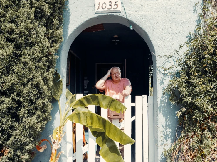 a man standing in the doorway of a house, by Carey Morris, pexels contest winner, pink arches, betty white, southern california, one man is blond