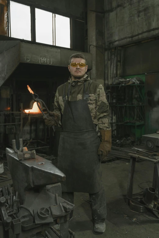 a man that is standing in front of a fire, inside iron and machines, man with glasses, metal garments, vitaly bulgarov