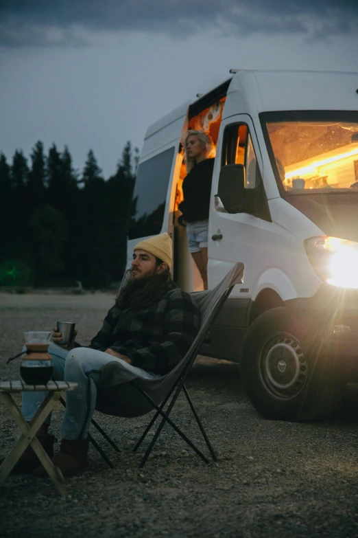 a man sitting in a chair in front of a van, by Tom Bonson, trending on unsplash, renaissance, glamping, evening lights, man and woman, looking threatening