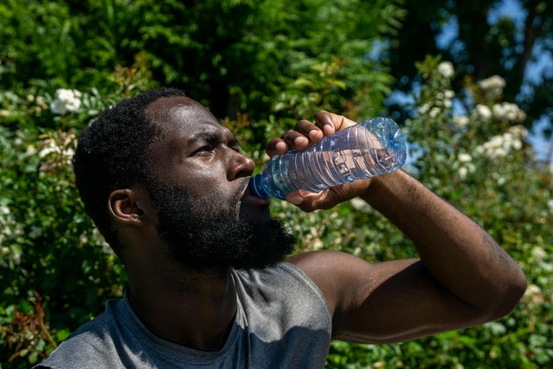 a man drinking water out of a plastic bottle, black curly beard, thumbnail, riyahd cassiem, slightly muscular