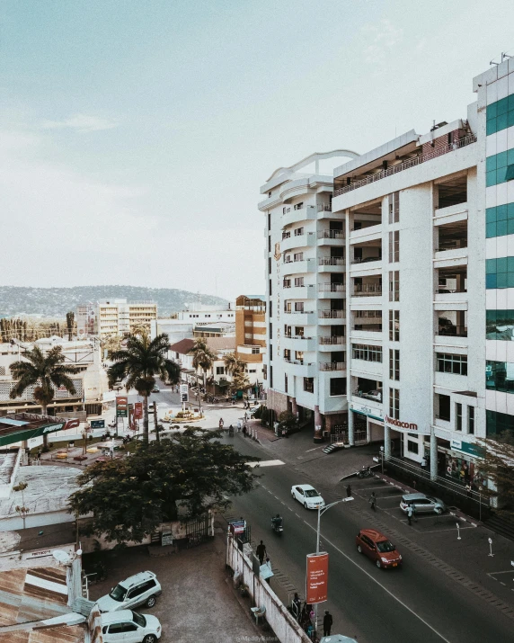 a city street filled with lots of traffic next to tall buildings, pexels contest winner, brutalism, madagascar, palm trees outside the windows, gif, ethiopian