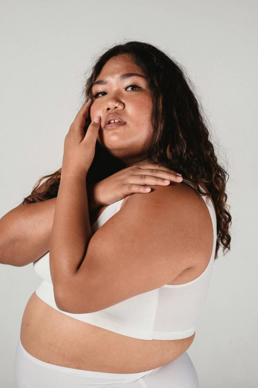 a woman in a white underwear posing for a picture, hand on cheek, slightly overweight, wearing crop top, promo image