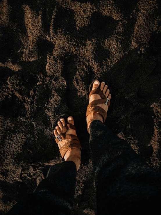 a person standing on top of a sandy beach, wearing a toga and sandals, ((rust)), trending on vsco, landslides