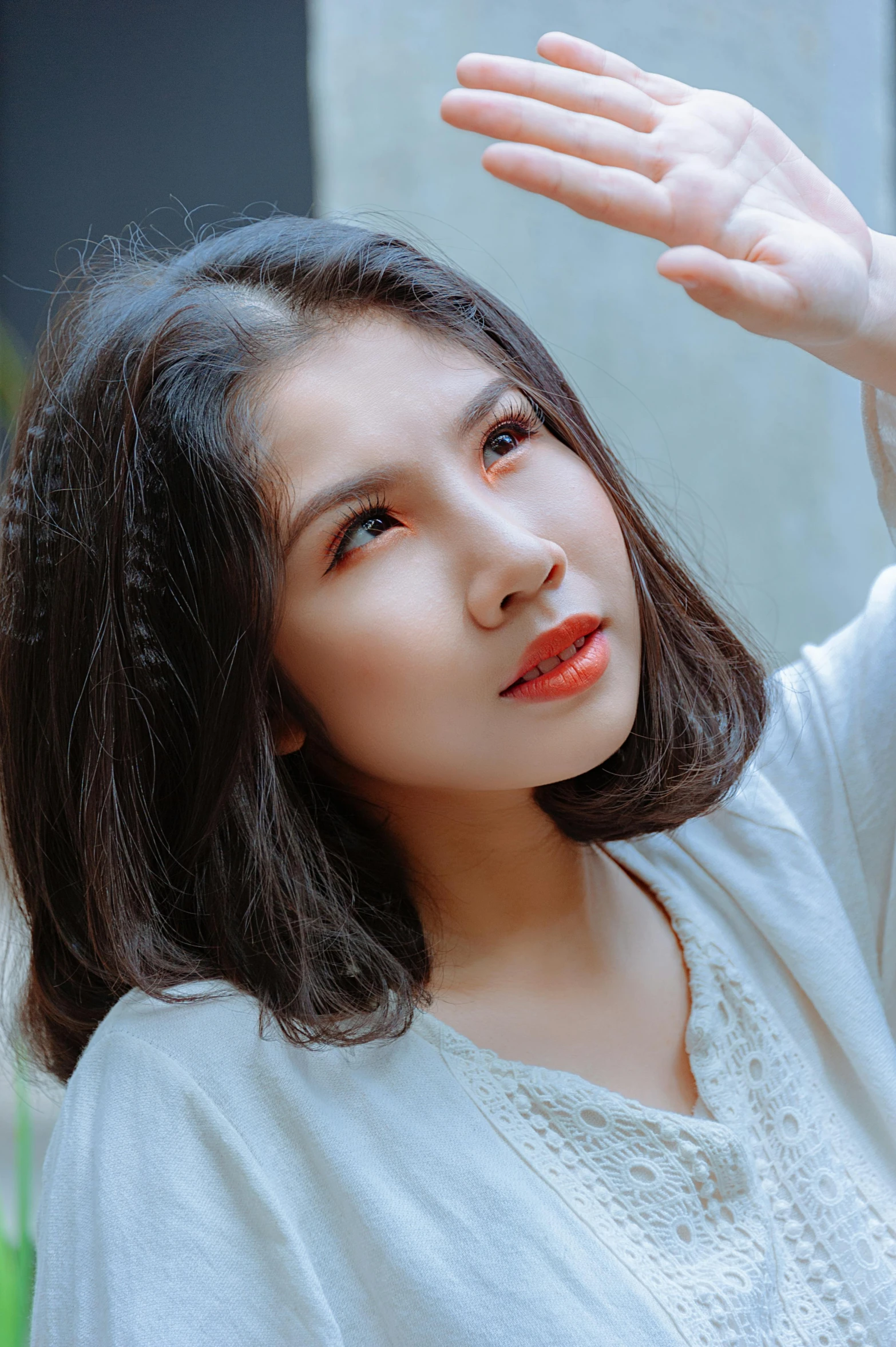 a woman holding her hand up in the air, inspired by Ruth Jên, pexels contest winner, realism, young cute wan asian face, square, lipstick, hair