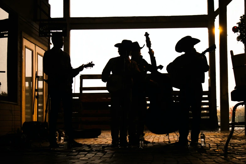 a group of people that are standing in front of a building, an album cover, by Carey Morris, pexels contest winner, cowboys, silhouette :7, inside a barn, musical instruments
