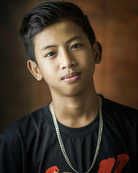 a young man in a black shirt posing for a picture, unsplash, sumatraism, aged 13, lgbt, ((portrait)), raden saleh