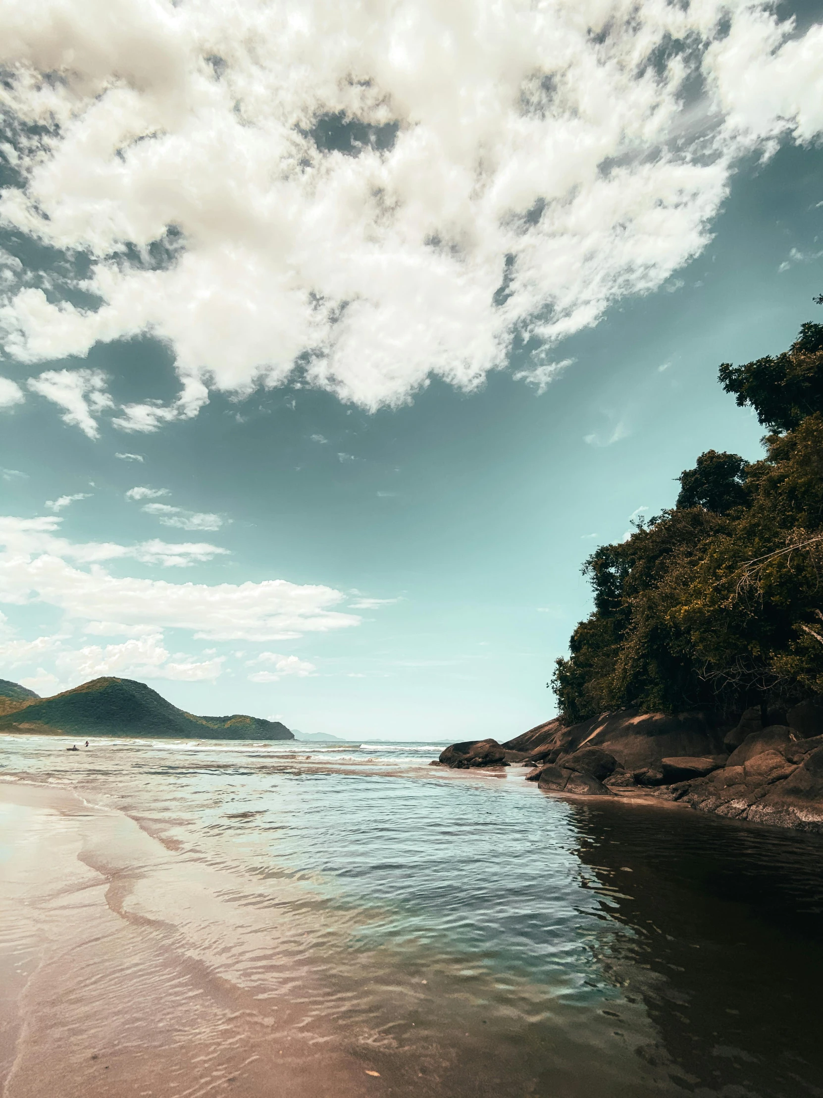 a man riding a surfboard on top of a sandy beach, by Felipe Seade, unsplash contest winner, hudson river school, trees and cliffs, brazil, 4 k cinematic panoramic view, slide show