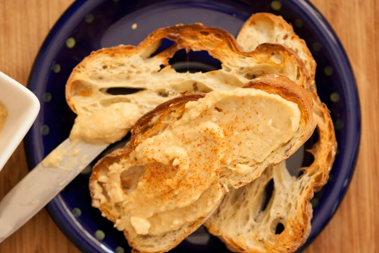 a blue plate topped with toast and a bowl of mustard, baking french baguette, intense face, bone to bone, humus