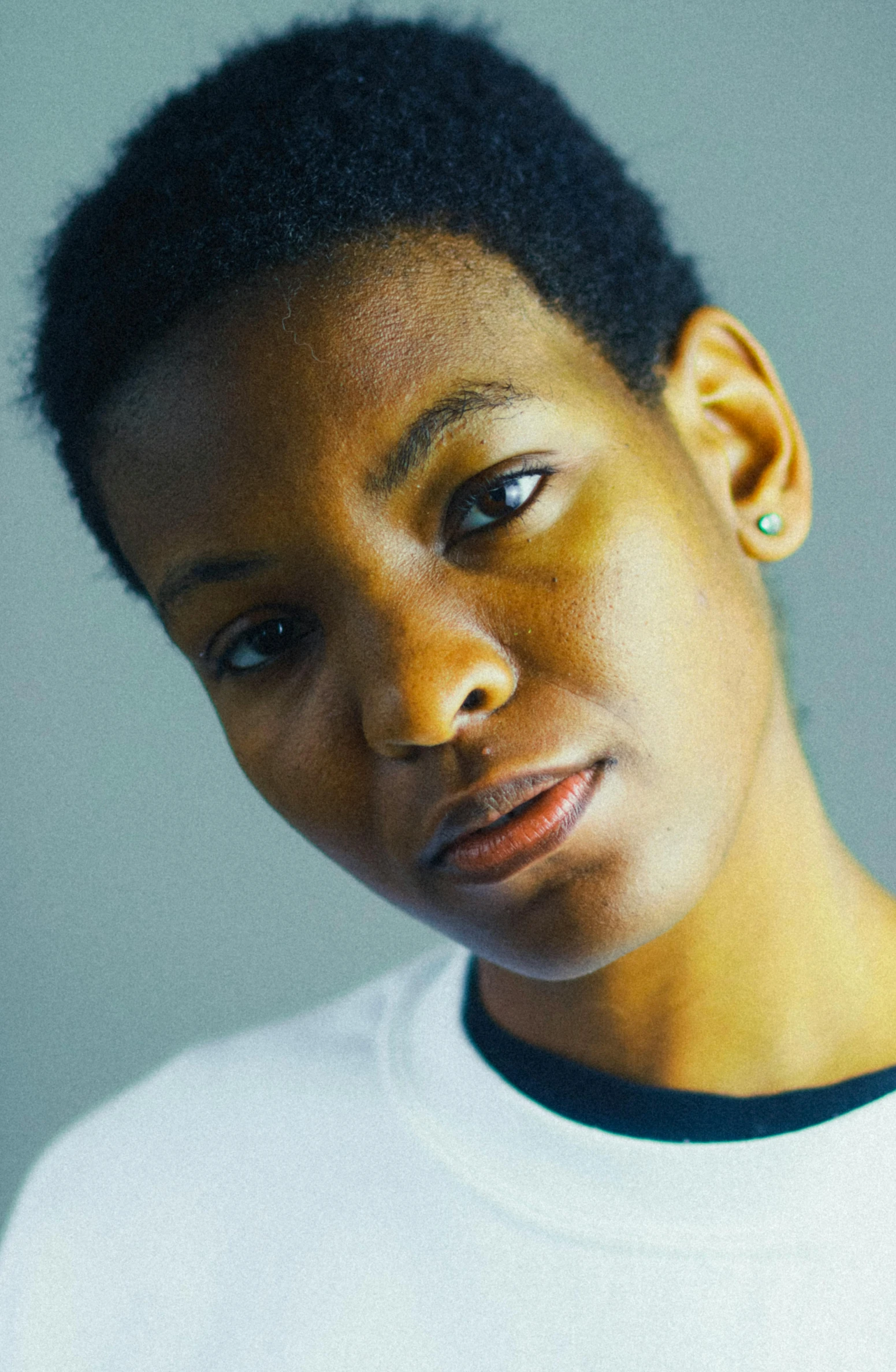 a close up of a person wearing a white shirt, by Lily Delissa Joseph, looking towards camera, maria borges, boyish face, promo image