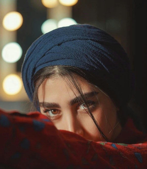 a close up of a person wearing a turban, trending on pexels, hurufiyya, girl with white eyes, looking back at the camera, blue and red tones, maya ali