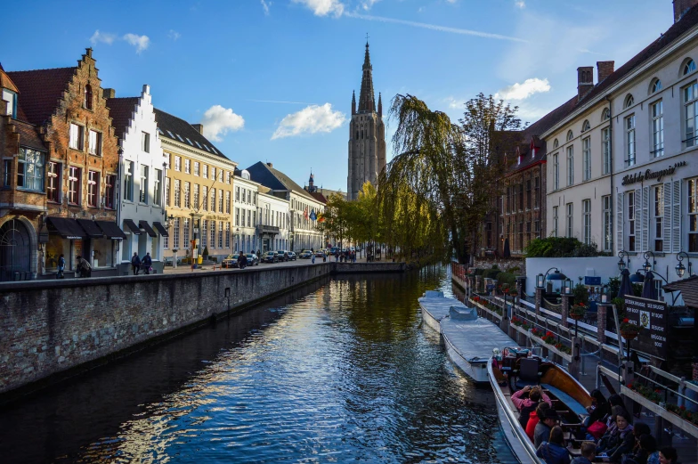 a river running through a city next to tall buildings, by Jan Tengnagel, pexels contest winner, cathedral in the background, flanders, square, thumbnail