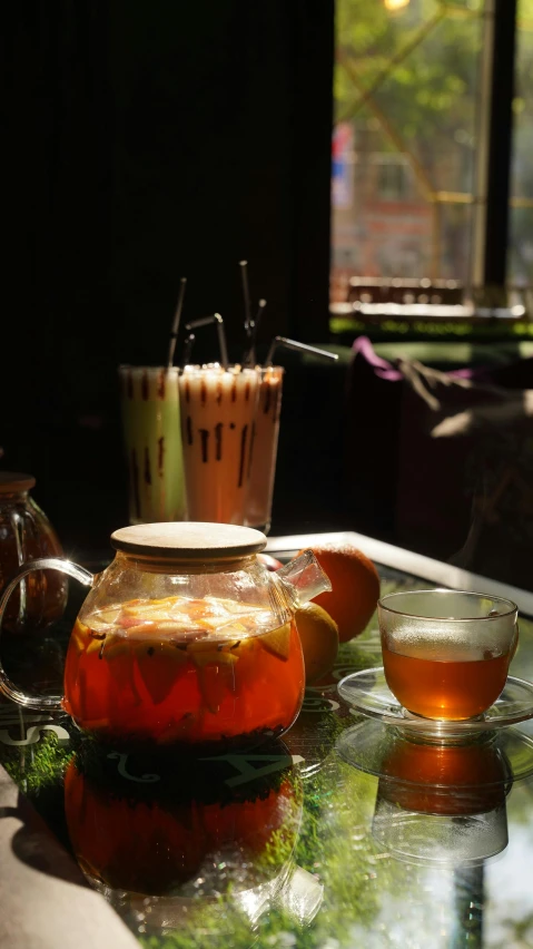 a glass tea pot sitting on top of a table, pexels, colored milk tea, in style of lam manh, cosy atmosphere, grain”