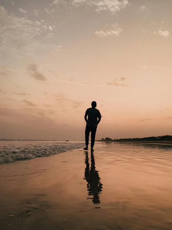 a man standing on top of a beach next to the ocean, during a sunset, profile image, run, non-binary