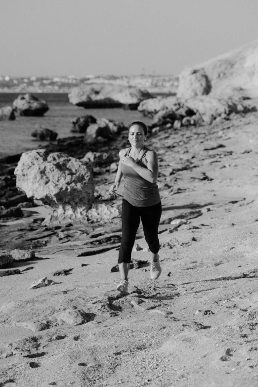a black and white photo of a woman on the beach, by Nathalie Rattner, happening, lunging at camera :4, in a mediterranean lanscape, sweat and labour, tri - x film