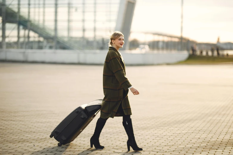 a woman walking with a piece of luggage, by Emma Andijewska, pexels contest winner, happening, over-knee boots, avatar image, irina nordsol kuzmina, doing an elegant pose