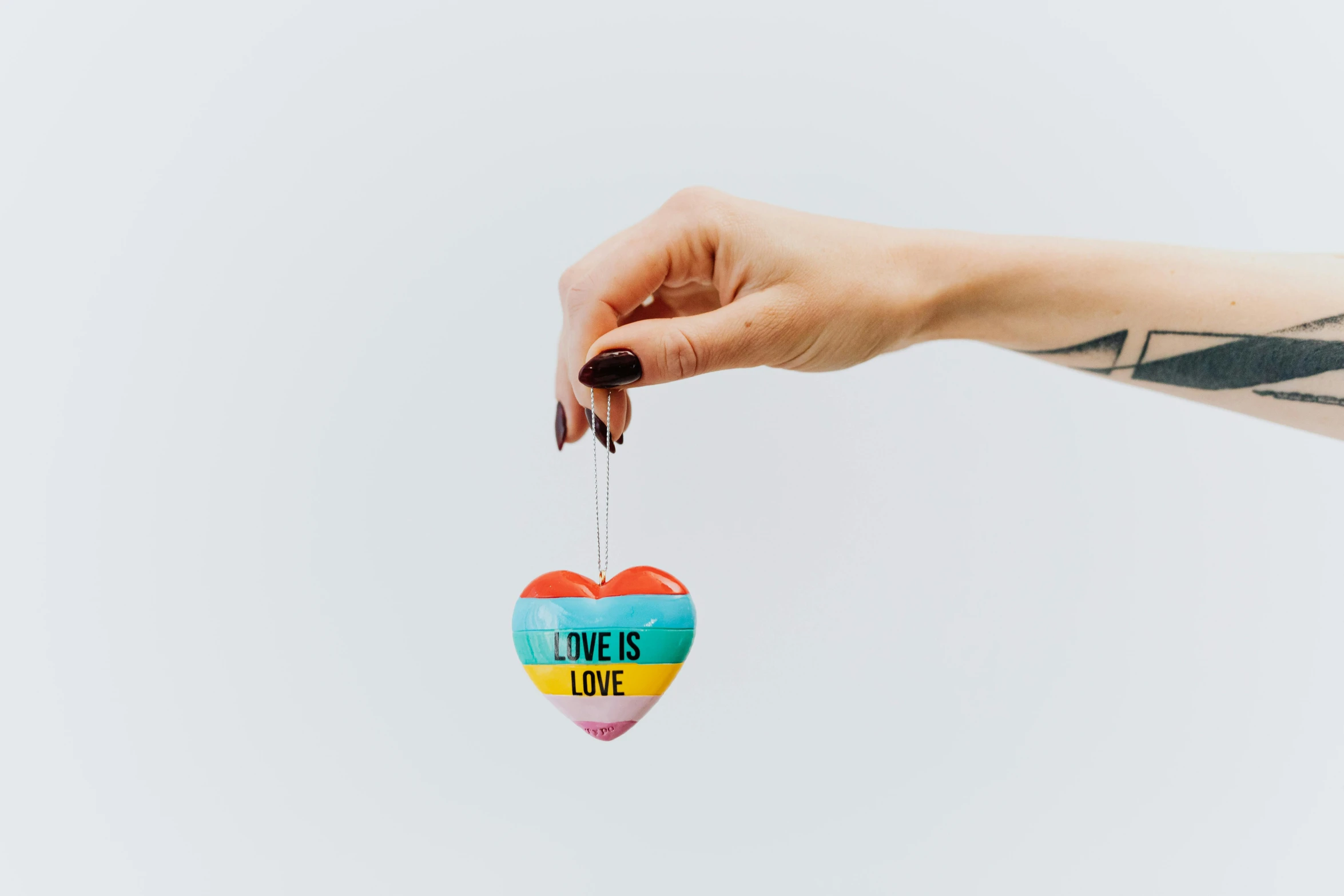 a person holding a heart shaped ornament, inspired by Okuda Gensō, unsplash, graffiti, on white background, striped orange and teal, love is begin of all, full product shot