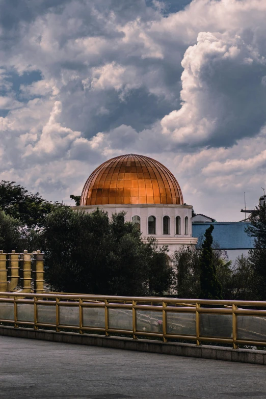 a view of the dome of the rock on a cloudy day, inspired by Buckminster Fuller, unsplash contest winner, orange roof, jamaica, 1990s photograph, military buildings