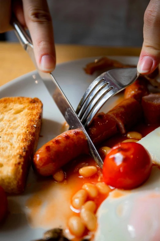 a close up of a plate of food with a knife and fork, by Steve Prescott, pexels contest winner, sausages, toast, arms down, baked beans