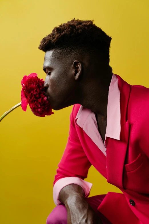 a man with a flower in his mouth, an album cover, pexels contest winner, maria borges, hot pink and gold color scheme, photo style of shawn paul tan, jaylen brown