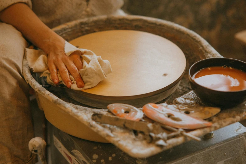 a person making a bowl of food on a potter's wheel, inspired by Ogata Kōrin, trending on unsplash, mingei, avatar image, thumbnail, holding a tower shield, professional photo