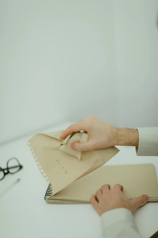 a close up of a person writing on a piece of paper, an album cover, beige, office clothes, punching in a bag, low quality photo