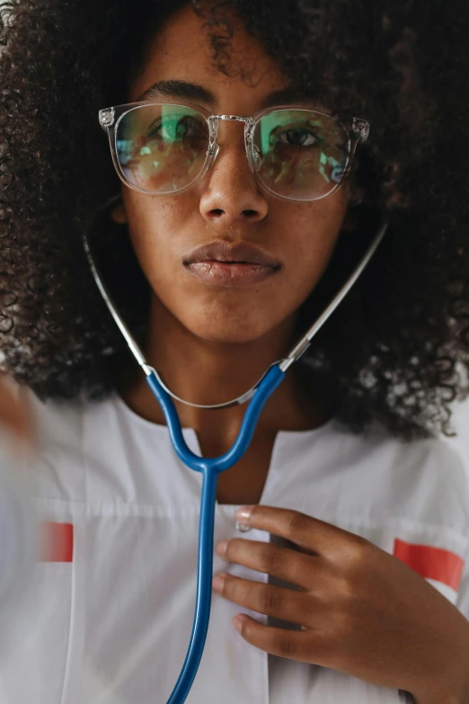 a close up of a person with a stethoscope, a picture, trending on pexels, nerdy black girl super hero, center of image, small square glasses, college