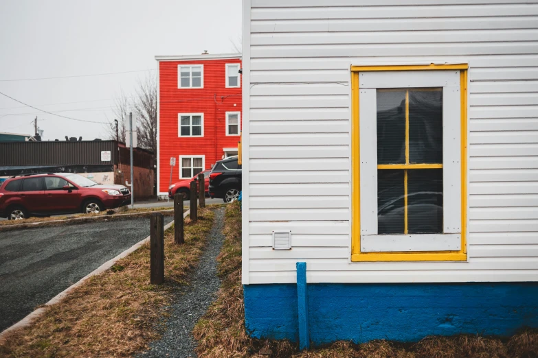 a red car parked in front of a white house, by Carey Morris, pexels contest winner, visual art, standing in township street, yellow windows and details, gauthier leblanc, seen from the side