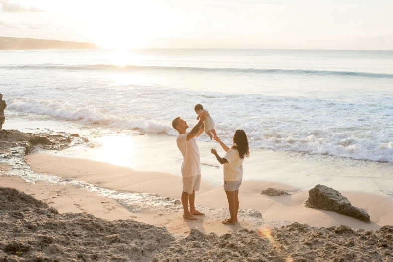 a couple of people standing on top of a sandy beach, toddler, with the sun shining on it, avatar image, families playing