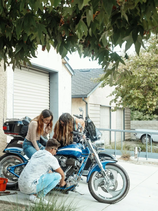 a couple of women sitting on top of a blue motorcycle, pexels contest winner, photorealism, people looking at a house, bay area, low quality photo, family photo