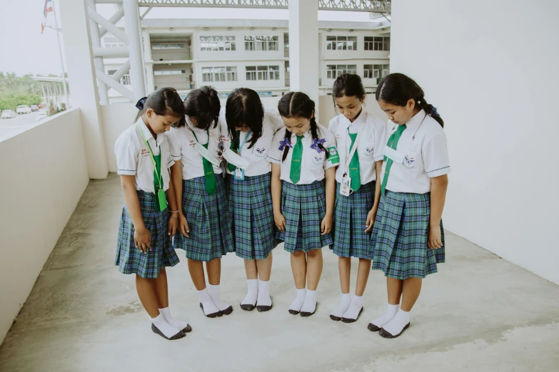a group of young girls standing next to each other, pexels contest winner, vancouver school, wearing green, wearing white skirt, thoughtful, standing on two feet