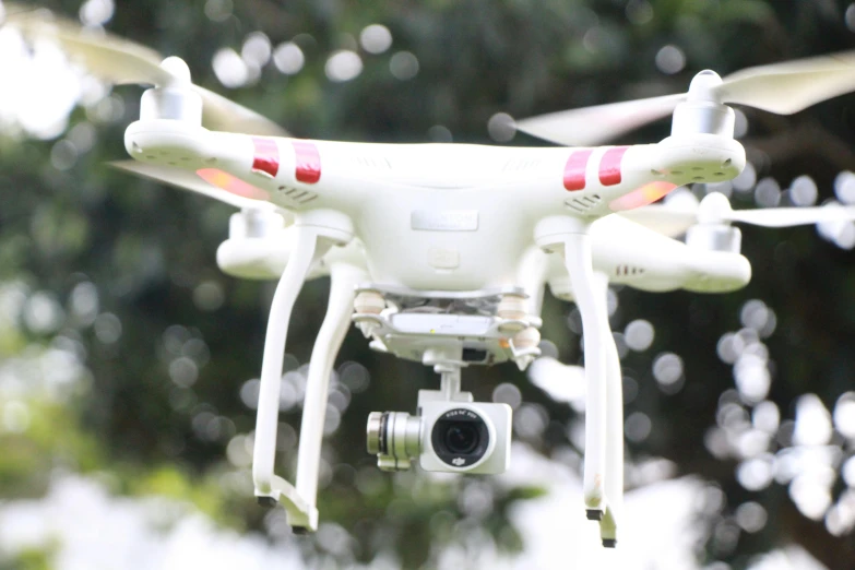 a white drone flying in the air with trees in the background, a picture, happening, camera looking down upon, student, instagram post, in 2 0 1 5