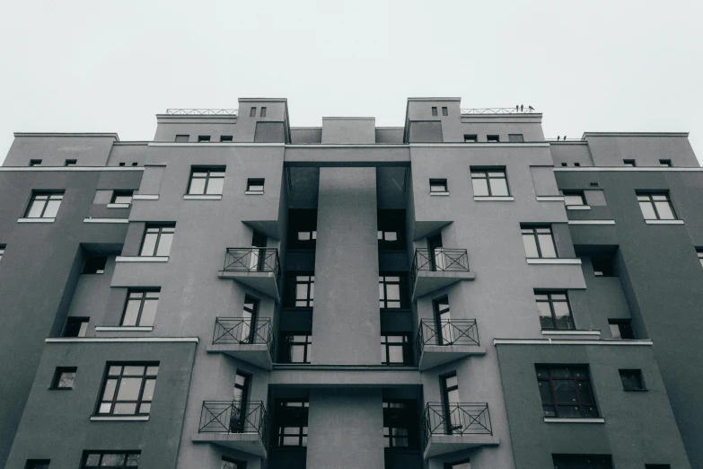 a black and white photo of a tall building, by Adam Marczyński, pexels contest winner, bauhaus, soviet apartment buildings, flat grey color, symmetrical front view, solid grey