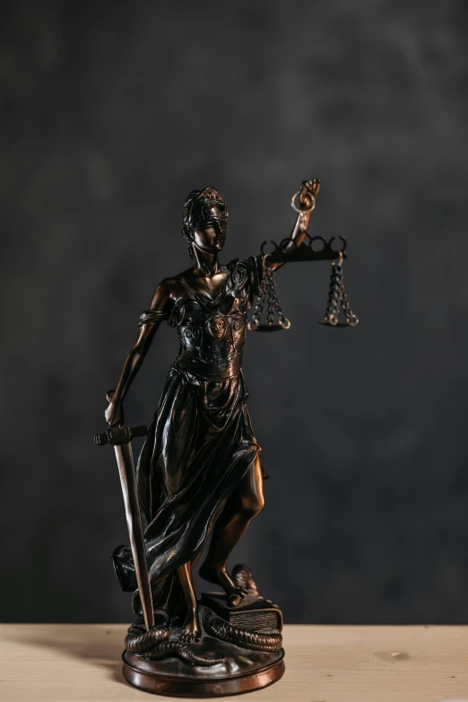a statue of lady justice holding a sword, a statue, by Adam Marczyński, pexels contest winner, on dark paper, tabletop miniature, islamic, high resolution