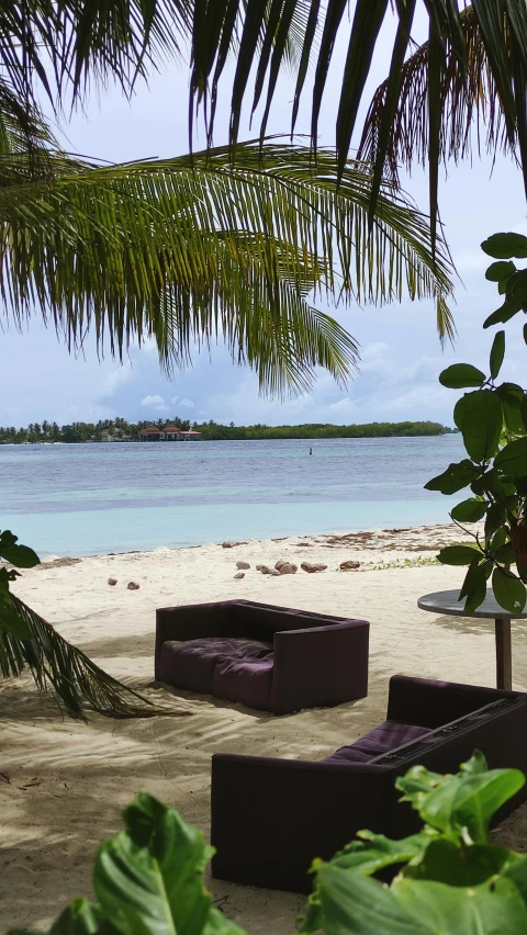 a couple of couches sitting on top of a sandy beach, an island, lounge, the window is open, no cropping