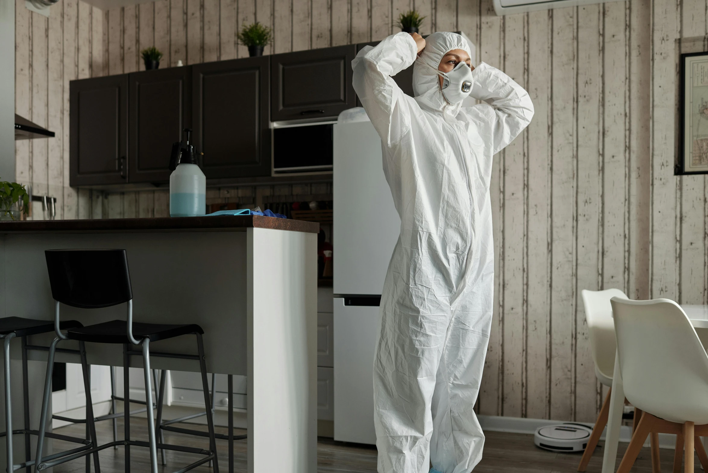 a man in a hazmat suit standing in a kitchen, pexels contest winner, plasticien, full body sarcastic pose, furniture overturned, profile image, wearing white pajamas