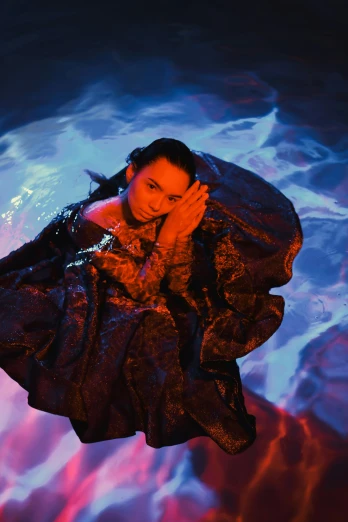 a woman floating in a pool of water, an album cover, chinese empress, shot with sony alpha 1 camera, glow, concern
